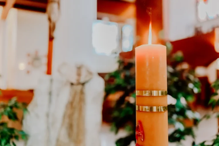 Świeca chrzcielna zapalona w kościele podczas uroczystości Chrztu Świętego