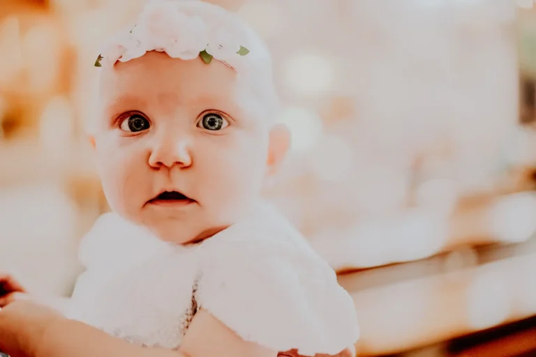 Niemowlę w białej sukience podczas Chrztu Świętego – fotografia reportażowa Łódź