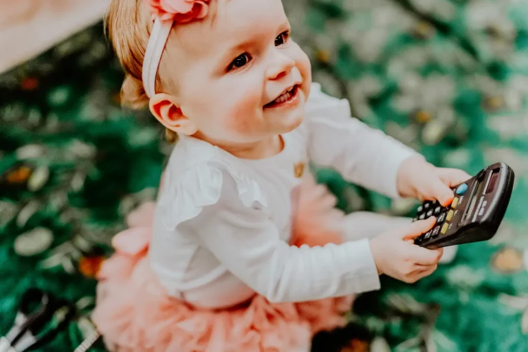 śmiechnięte dziecko w białej bluzce i różowej spódniczce podczas przyjęcia chrzcielnego