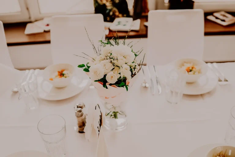 Dekoracja stołu na przyjęciu z okazji Chrztu Świętego – kwiaty i elegancka zastawa